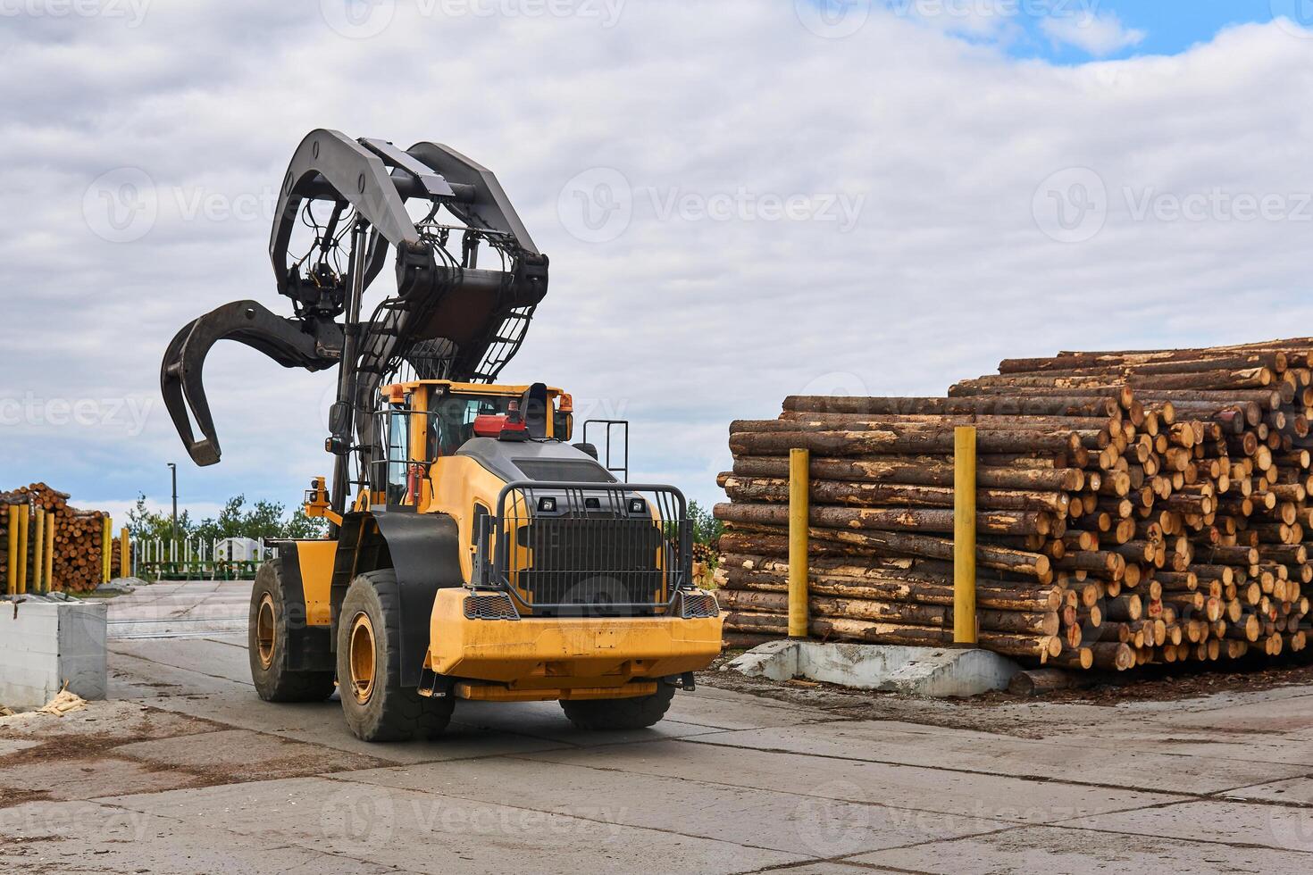 grapple loader in the lumber yard of a woodworking plant photo