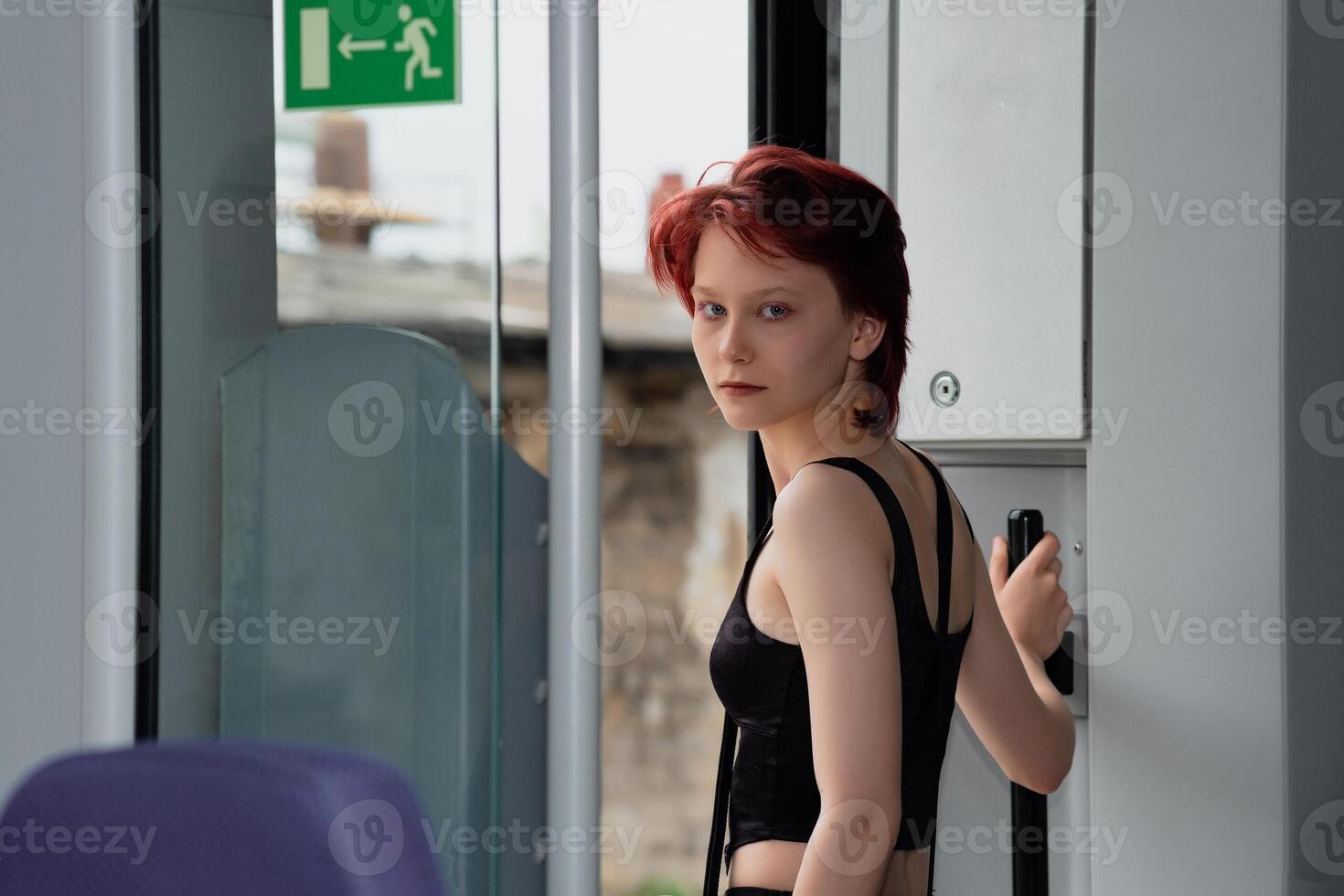 teenager girl is preparing to get off at a station from a commuter train car photo