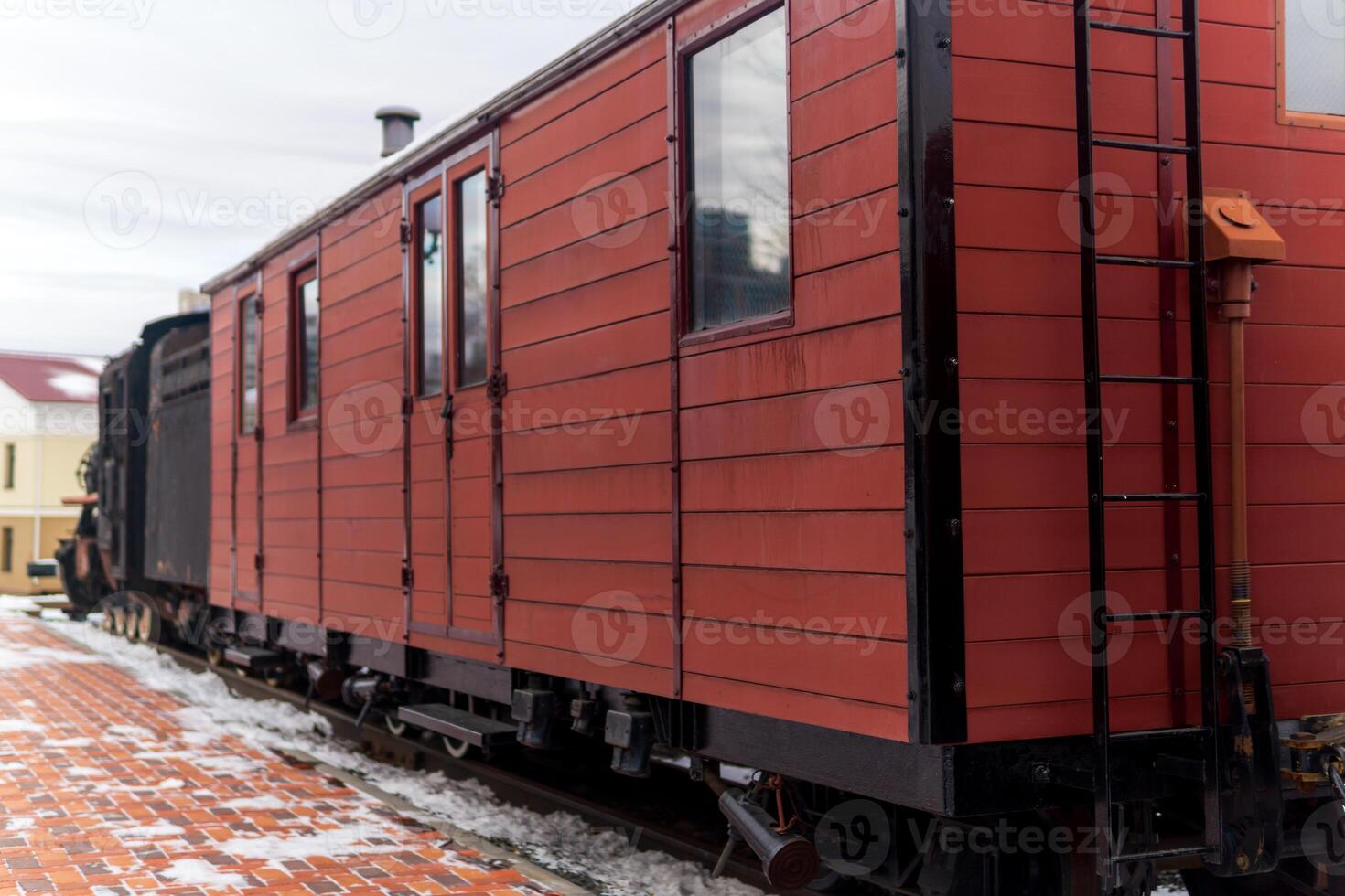 vintage boxcar with a steam locomotive at the station in winter photo