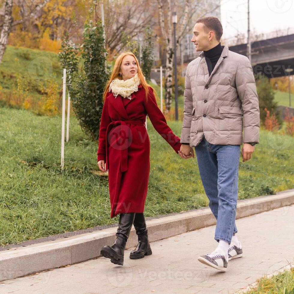 young couple walking in the autumn park photo