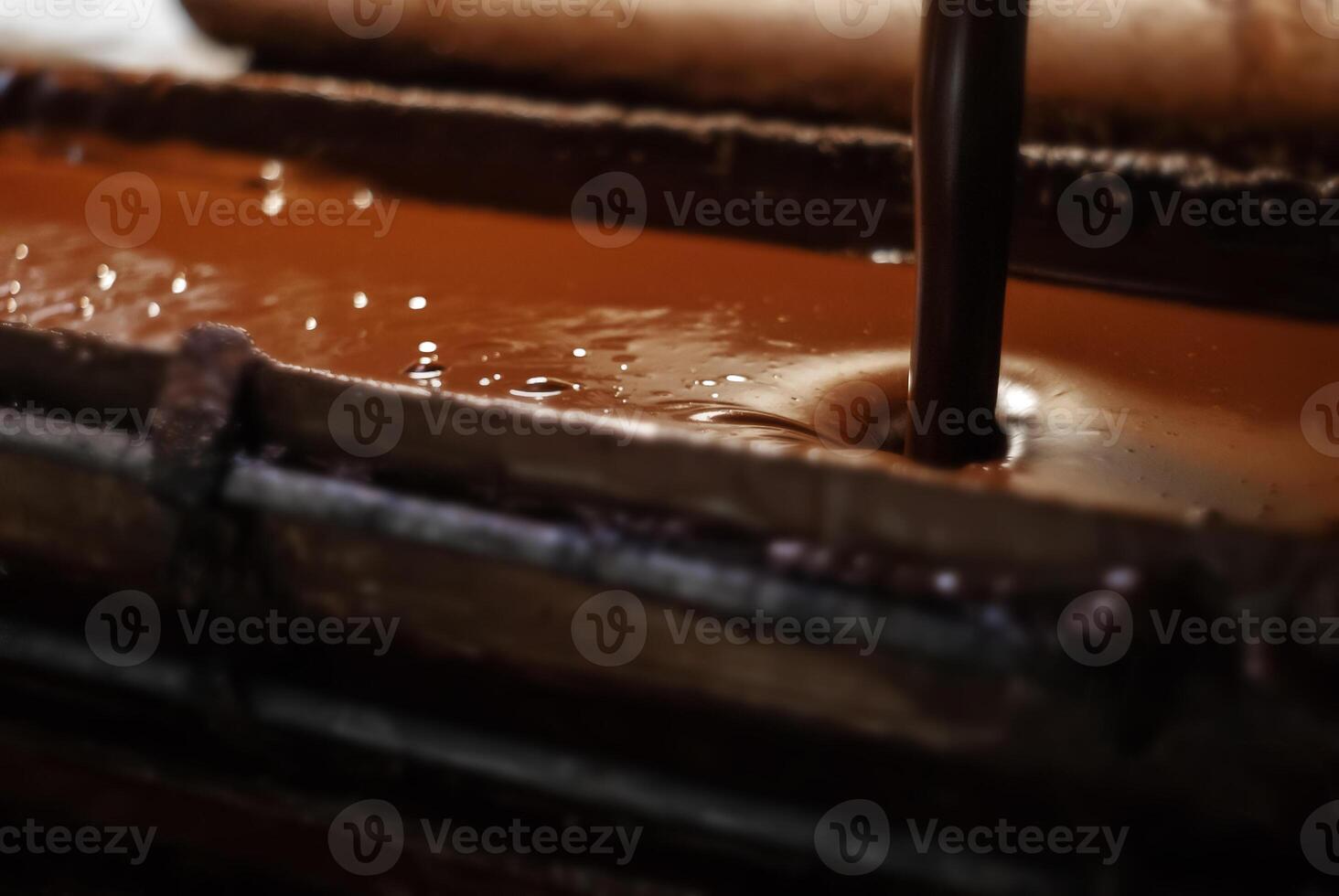 molten chocolate poured into a tray in a confectionery factory, close-up photo