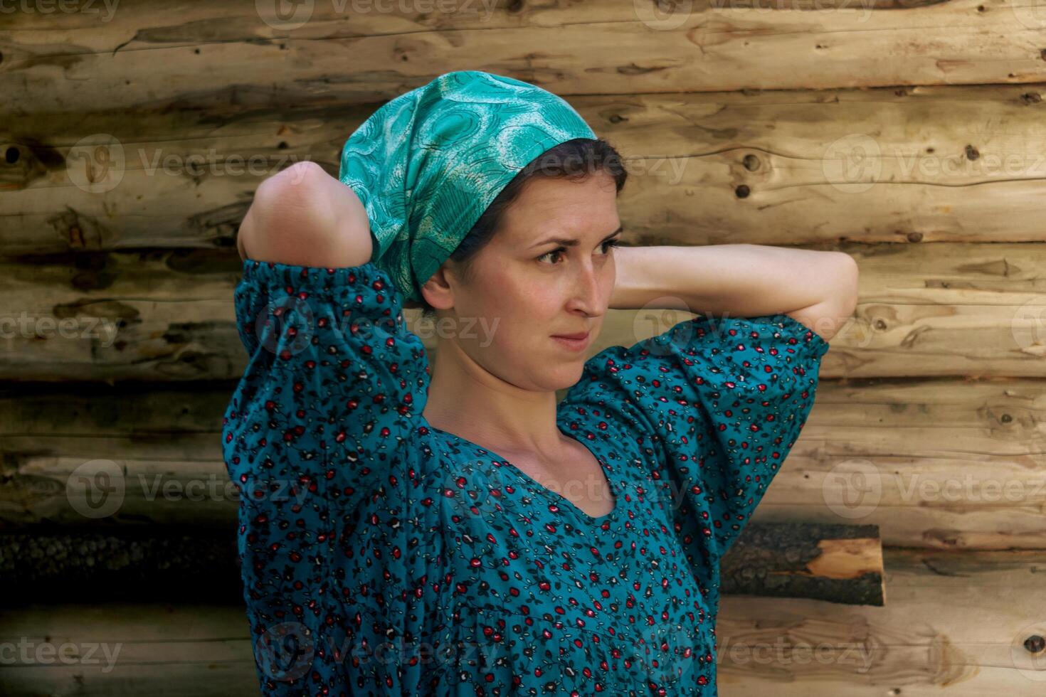 portrait of a woman in a traditional peasant dress and a headscarf against the background of a log wall photo