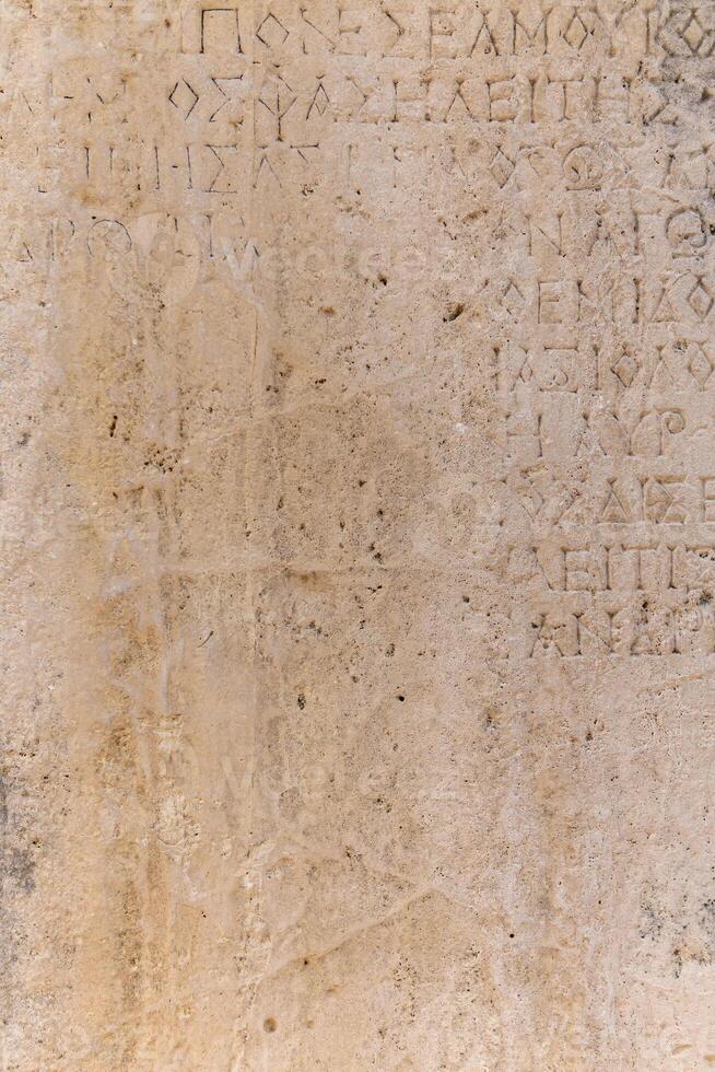 almost erased ancient Greek inscription on the stone photo