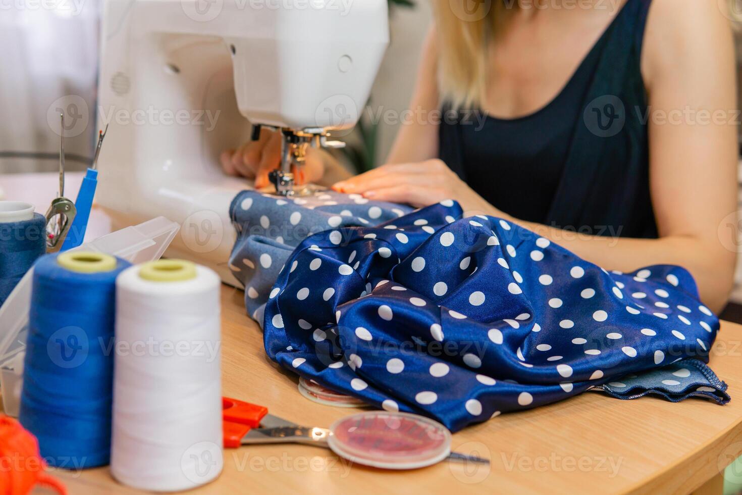 borroso manos de un modista mujer trabajando en un de coser máquina foto