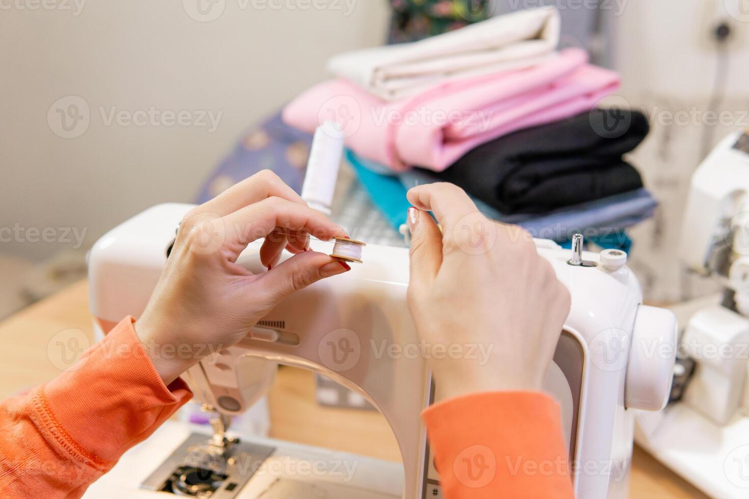 seamstress winding thread from spool to bobbin, close-up photo