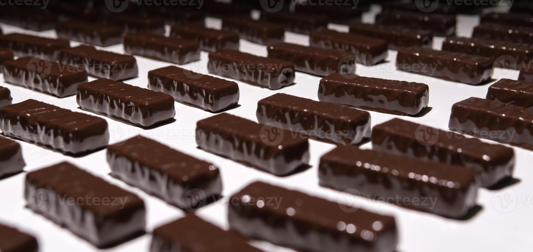 chocolate candies on the conveyor of a confectionery factory close-up photo