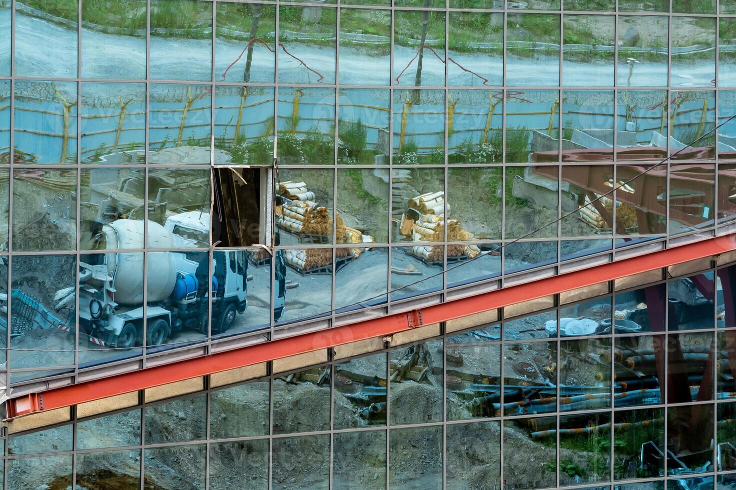 industrial background - a mirror wall of an unfinished building, which reflects the construction site photo