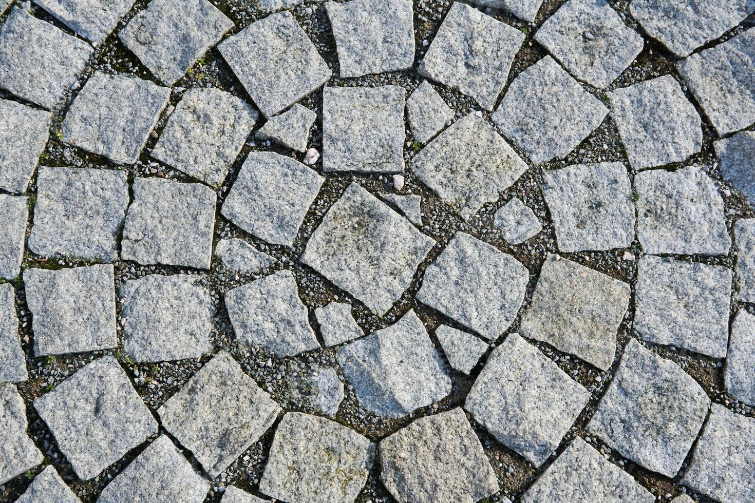 background - fragment of an old sidewalk paved with granite paving stones photo