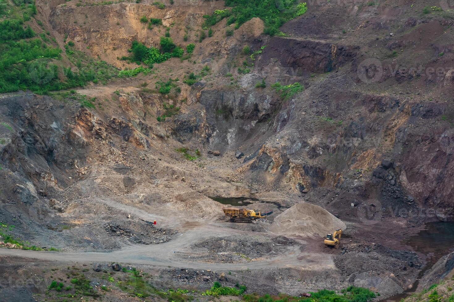 small quarry with mining machinery in mountainous area photo