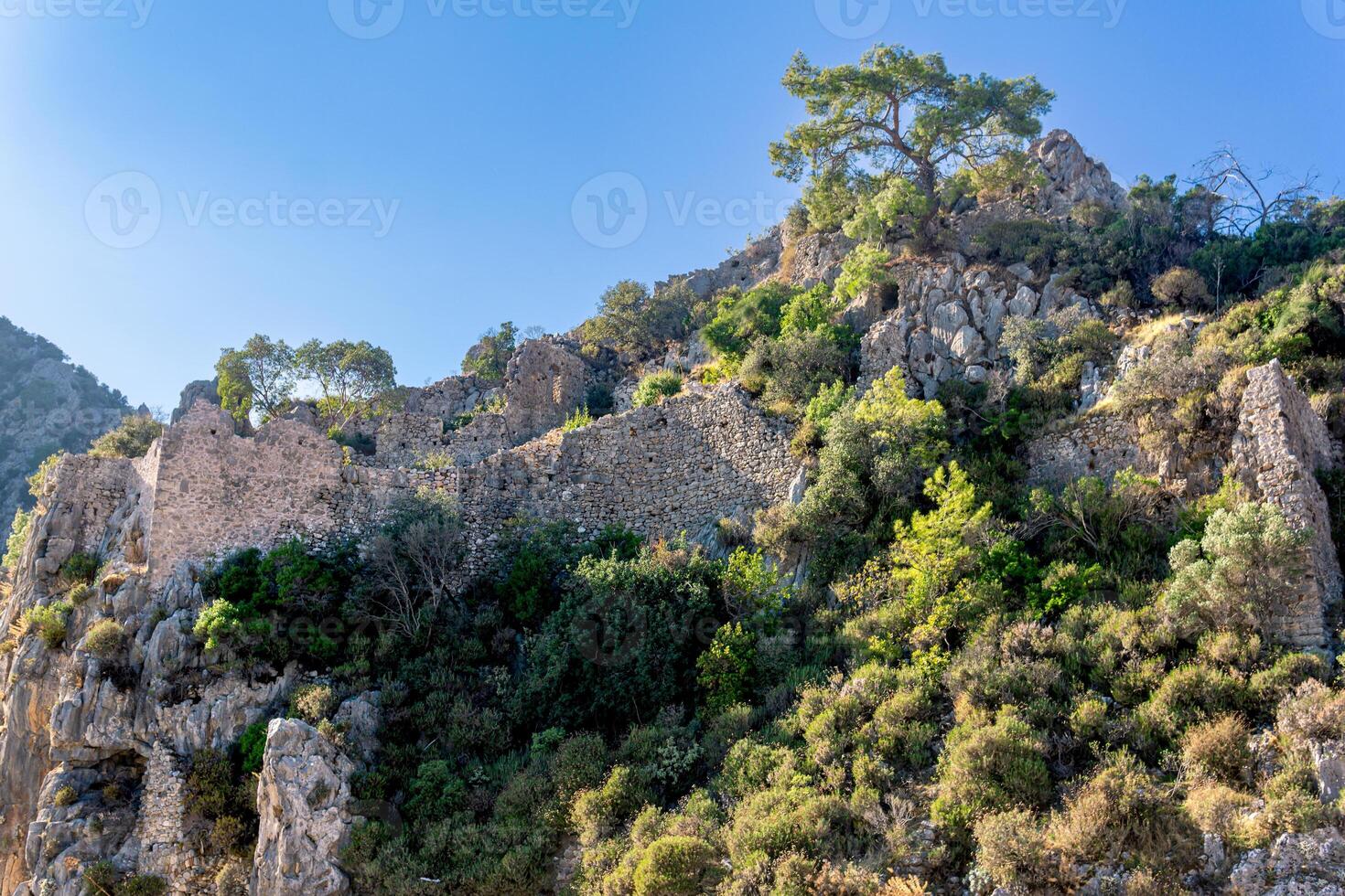 ruins of fortress walls on rocky mountain slopes near the antique city of Olympos, Turkey photo