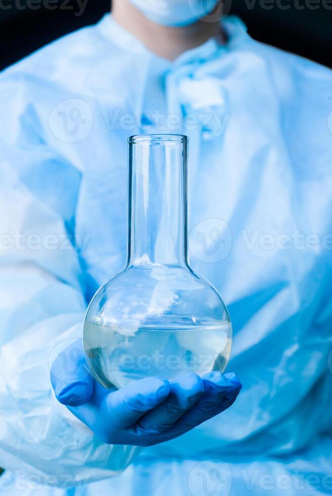 laboratory flask with a liquid in a researcher hand photo