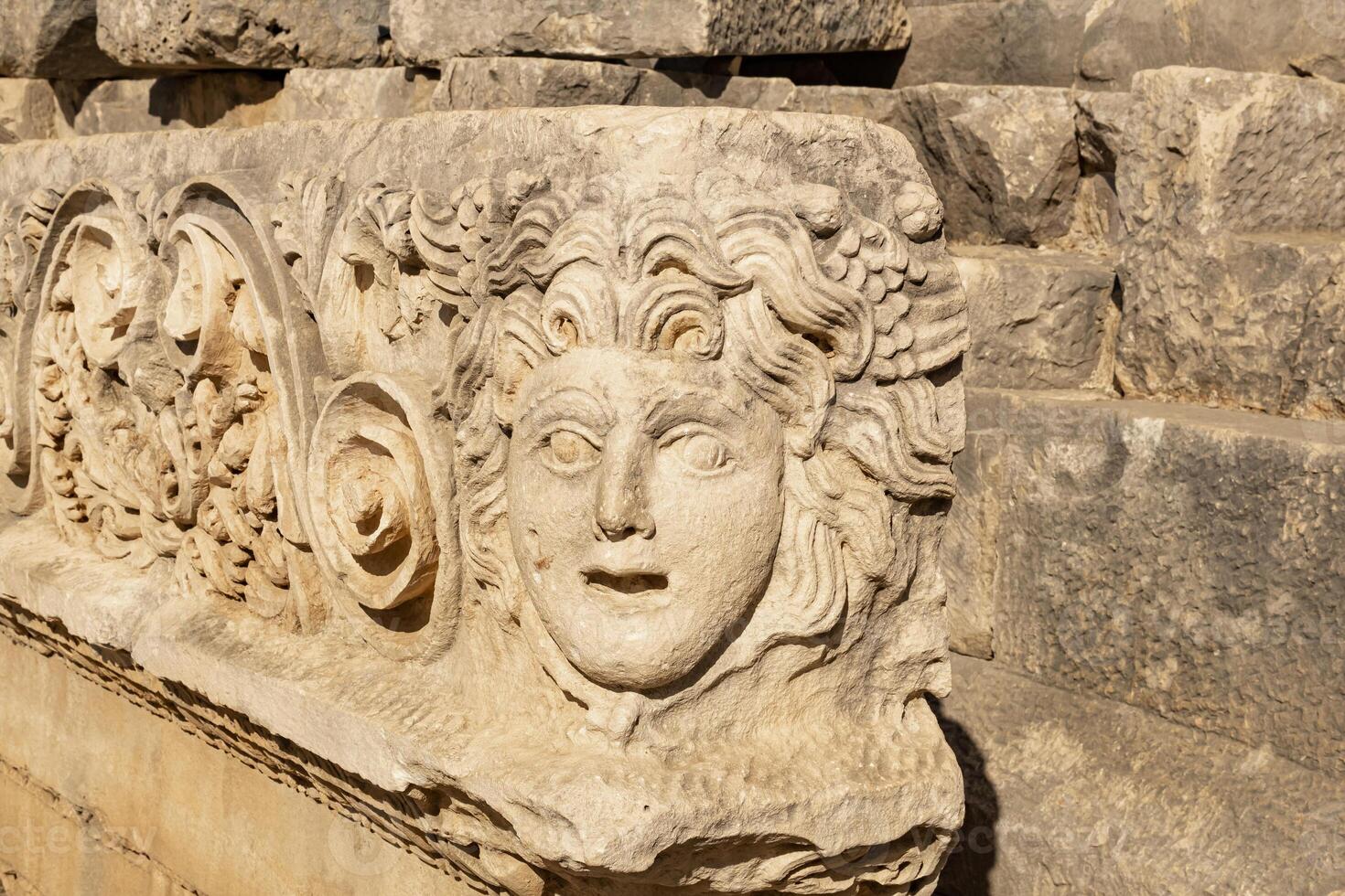 antiguo friso con tallado en piedra máscara en el restos de el antiguo ciudad de mira, Turquía foto