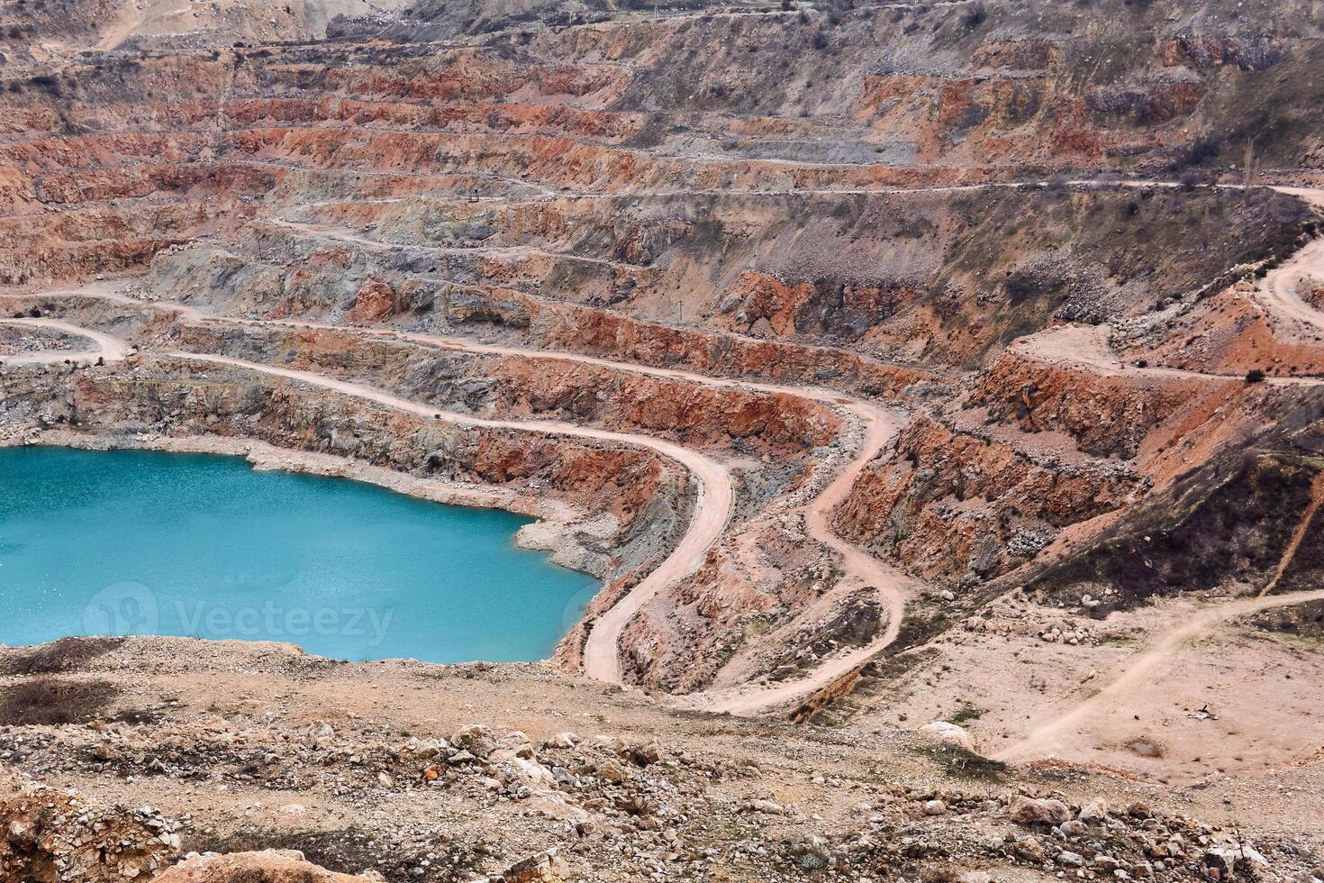 section of an old limestone quarry with a blue lake at the bottom photo