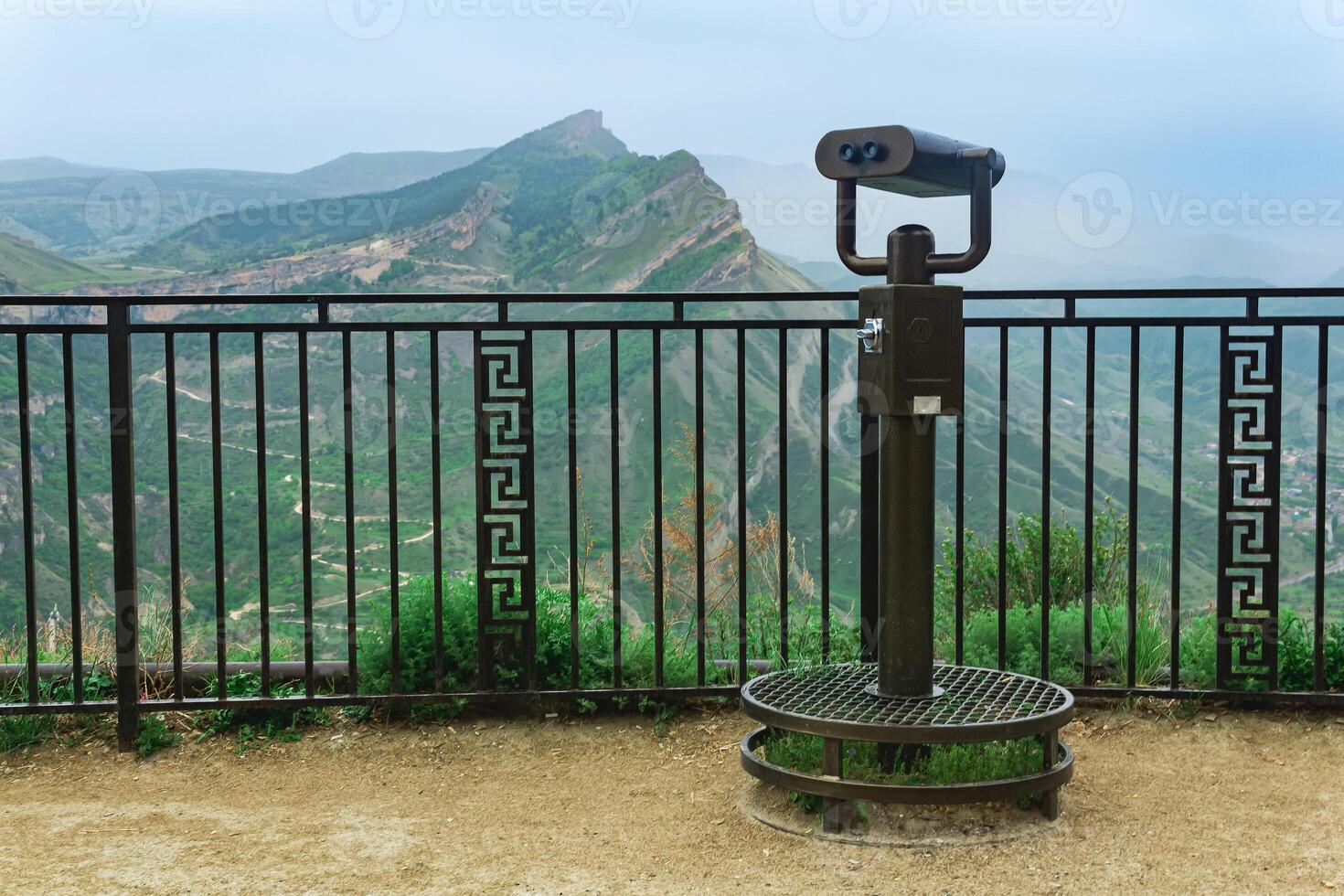 observation deck with a spotting scope over a mountain valley photo