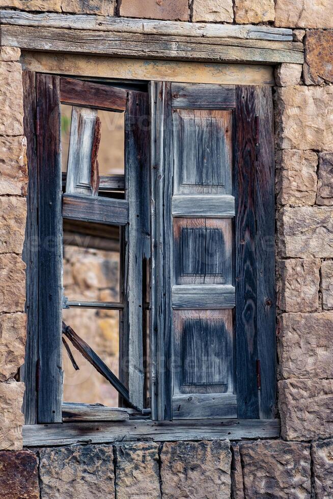 old window with wooden broken shutters in the ghost village of Gamsutl in Dagestan photo