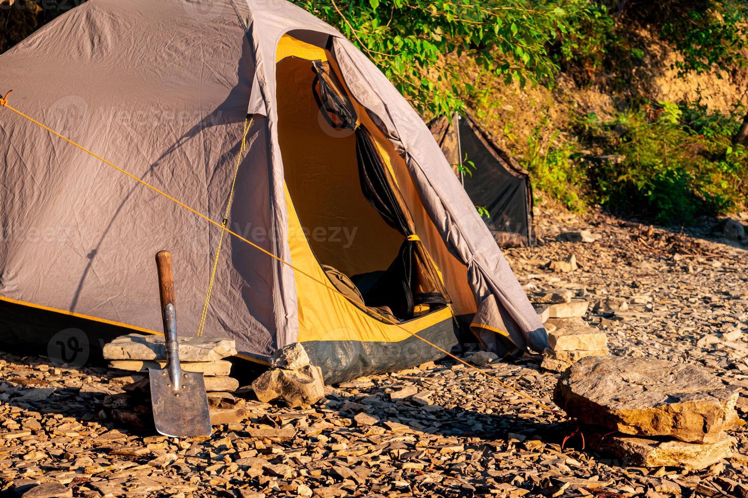 hike camp on a rocky shore, dome frame tent photo