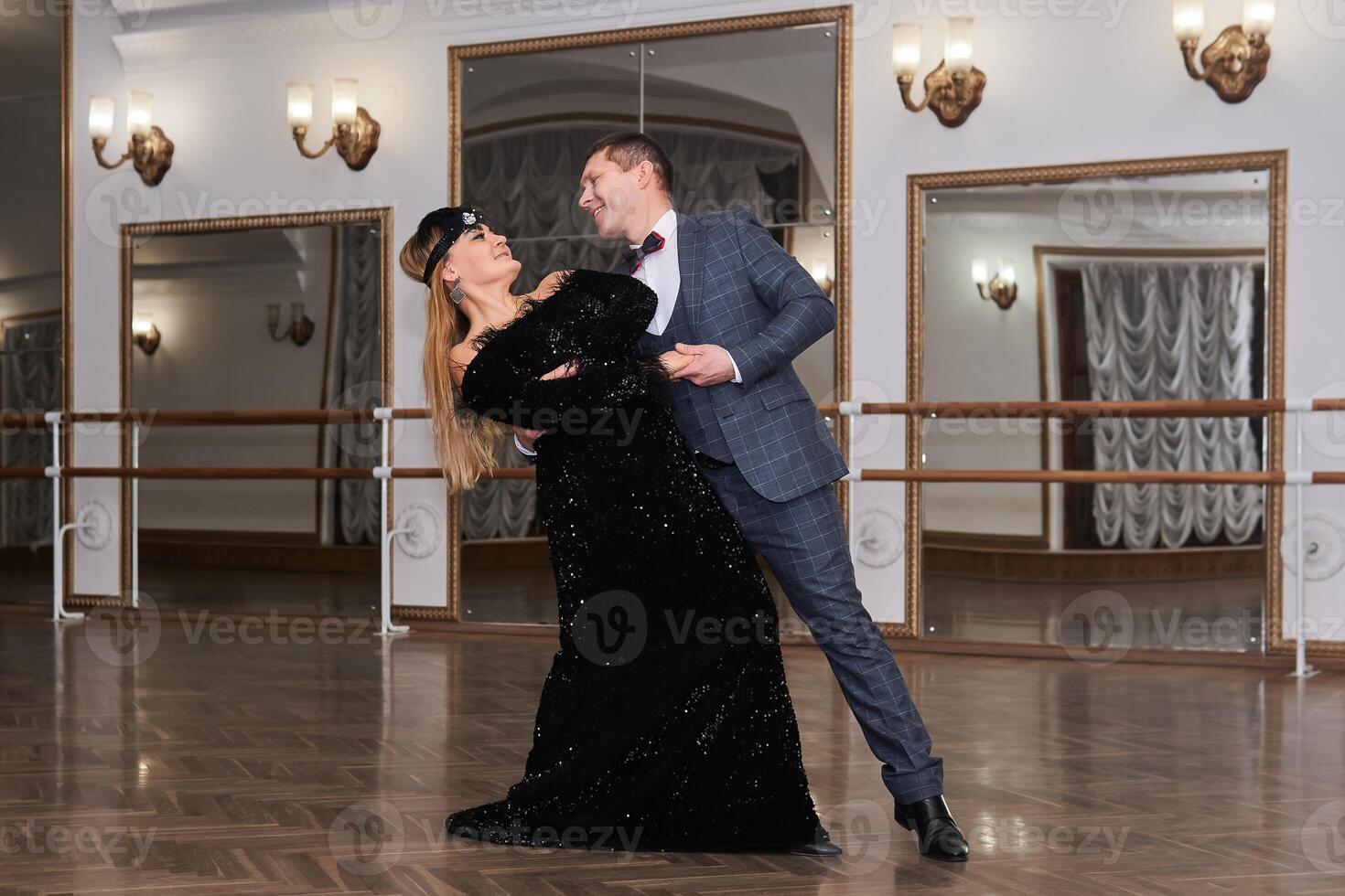 man and woman amateur dancers laugh during classical dance with each other photo