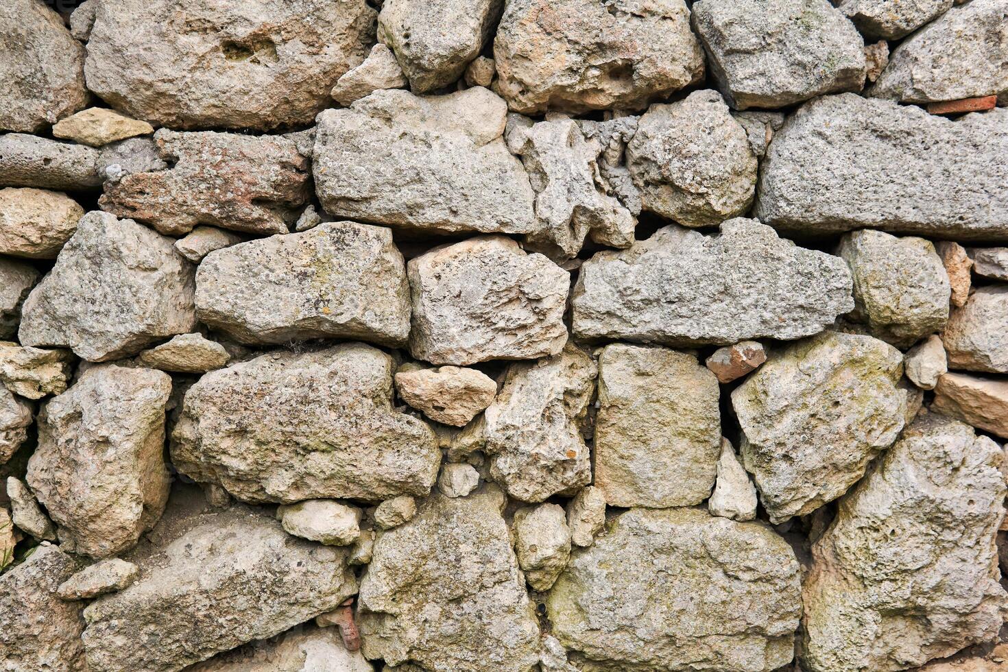 background, texture - old dry stone masonry without mortar for binding stones photo