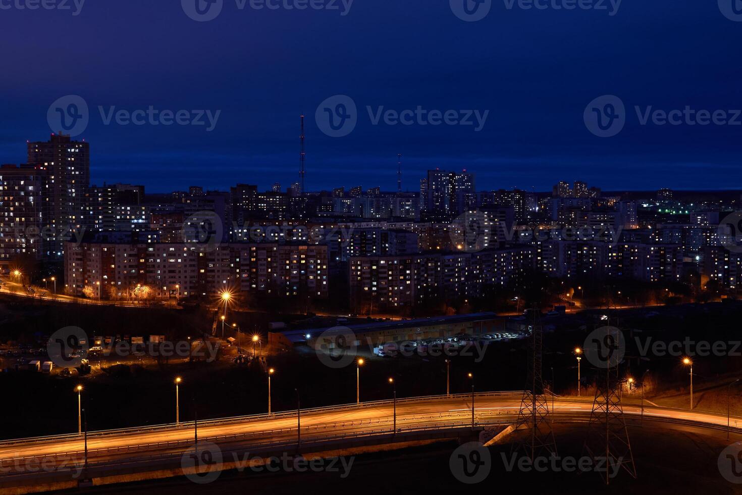 night cityscape with illuminated road in the foreground and residential areas in the background photo