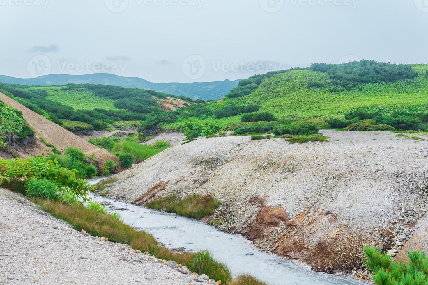 warm hydrogen sulfide stream among the banks of volcanic ash and tephra in the caldera of Golovnin volcano, Kunashir island photo