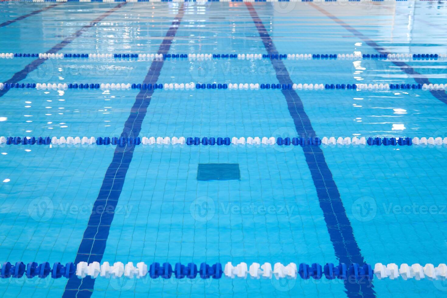 fragment of the competition pool with blue water and marked swimming lanes photo