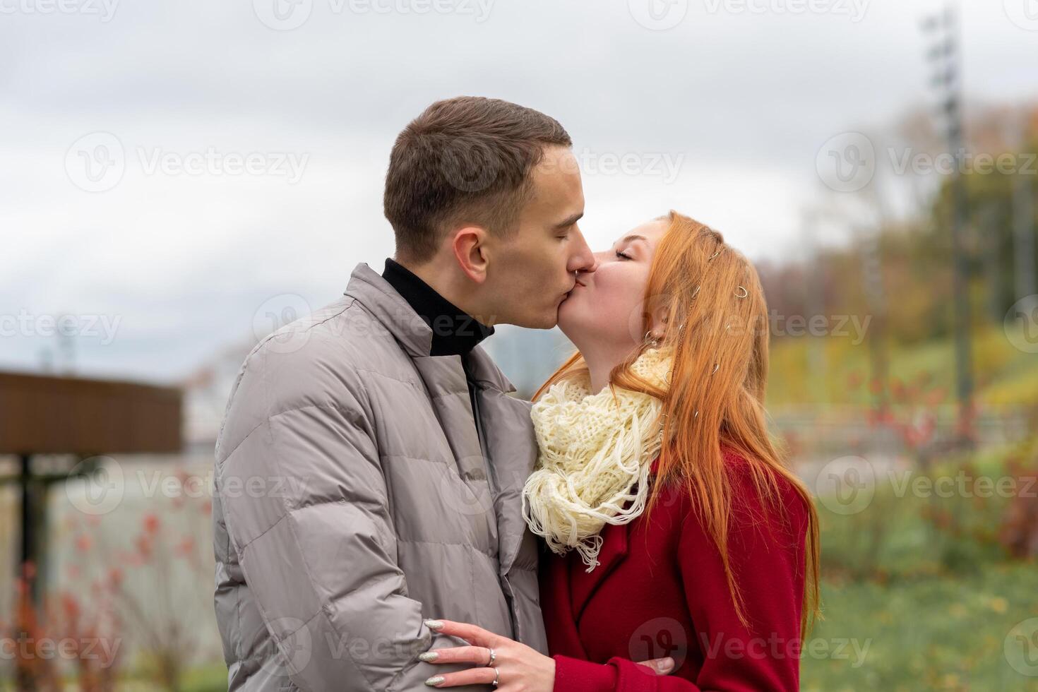 young couple kissing outdoors photo