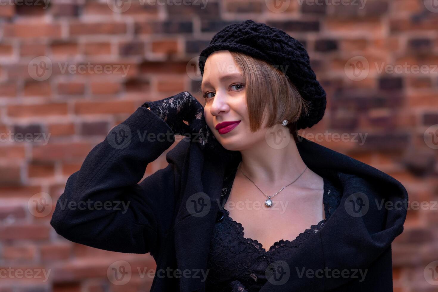 joven mujer en boina en retro estilo en un ladrillo pared antecedentes foto