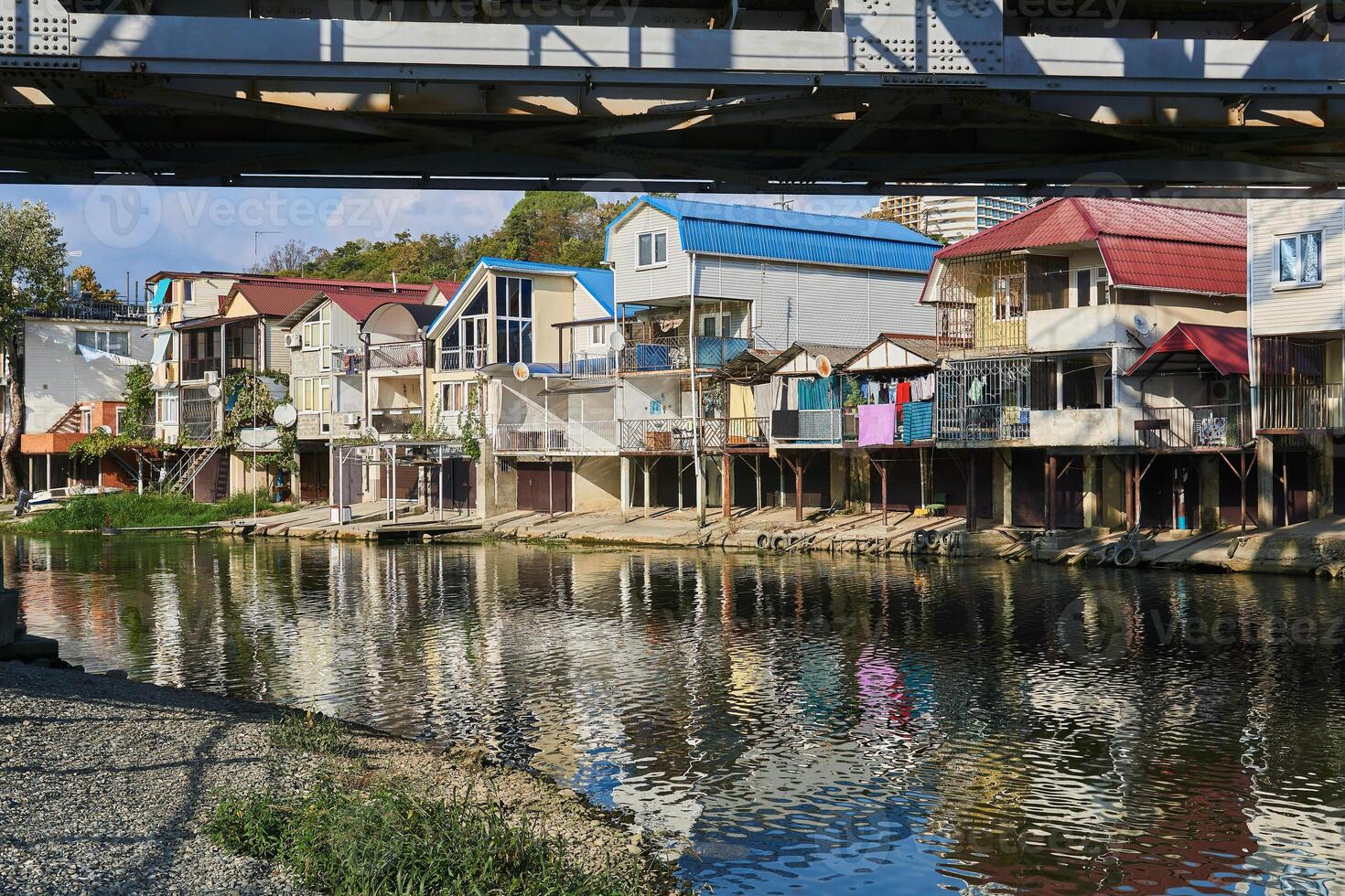 the bank of the Dagomys river is built up with small cottages with garages for boats photo