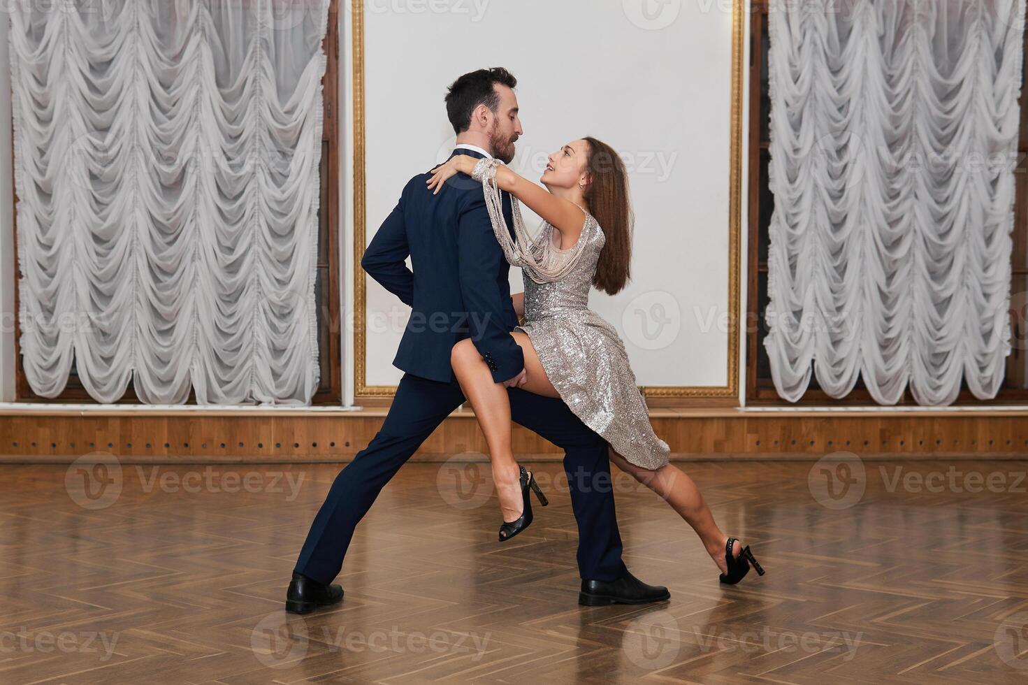 dance training, man and woman practice tango elements in the ballroom photo