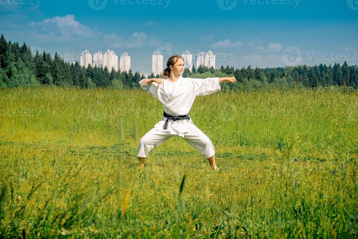 teen girl training karate kata outdoors photo