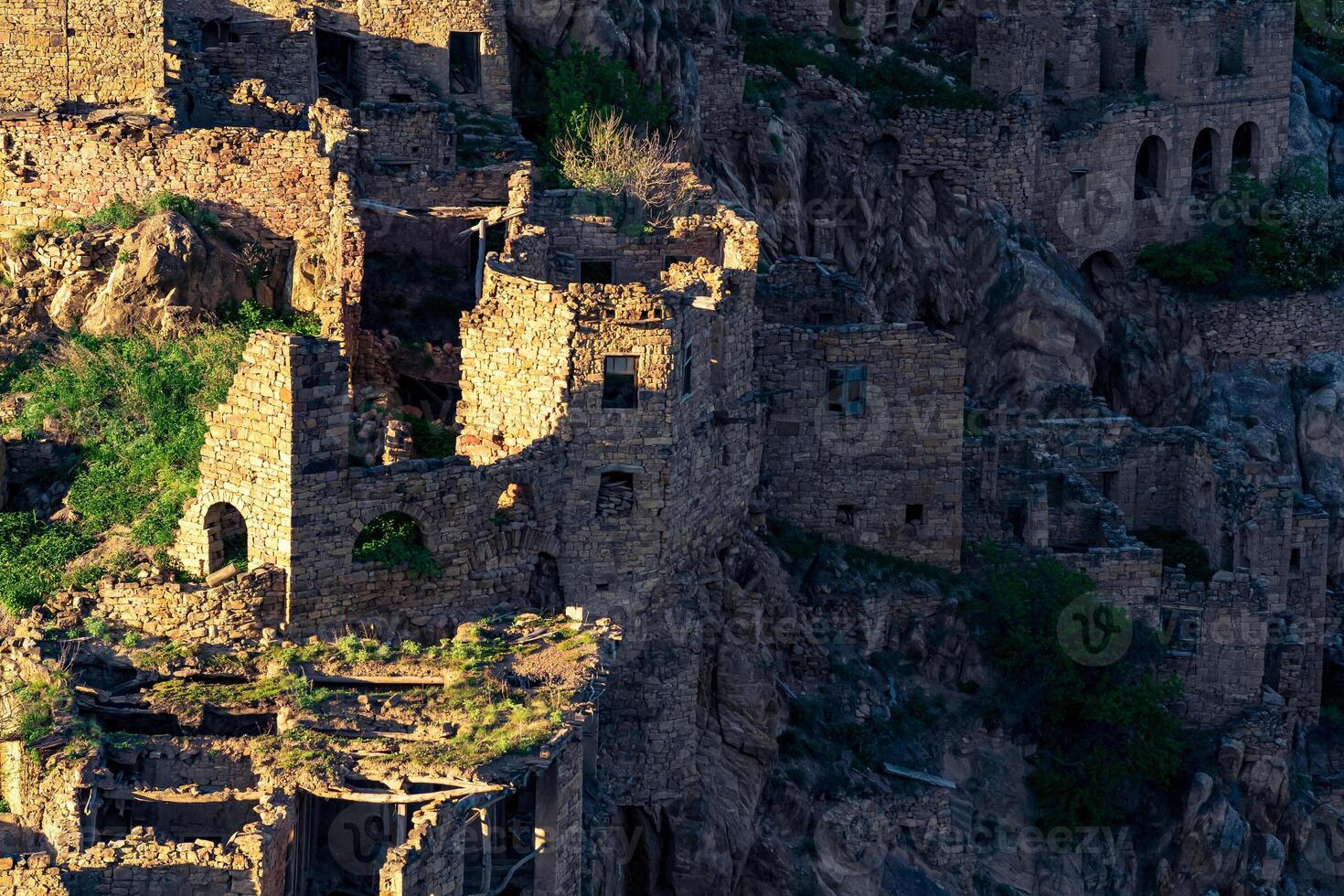 evening view of the ruins of the ghost village of Gamsutl, illuminated by the last rays of the sun photo