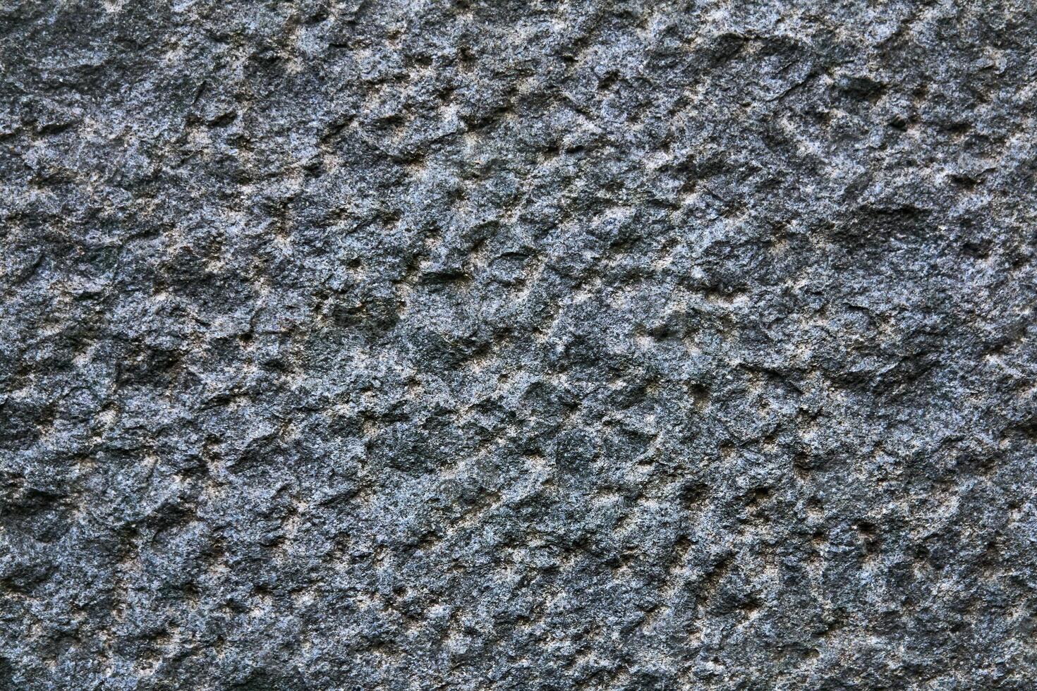 background, texture - the surface of a roughly hewn granite block photo
