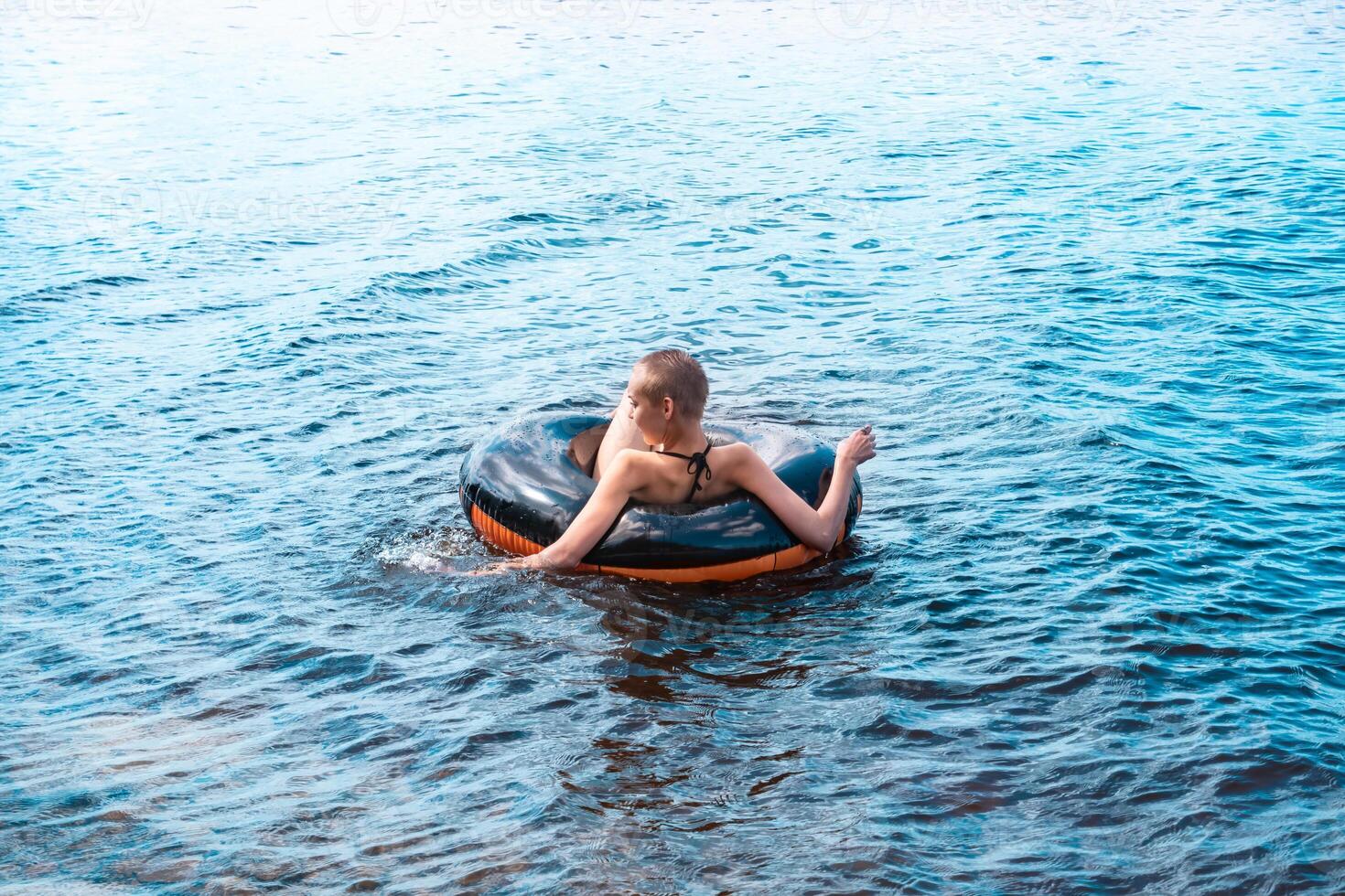 teen girl swimming using a swim tube photo