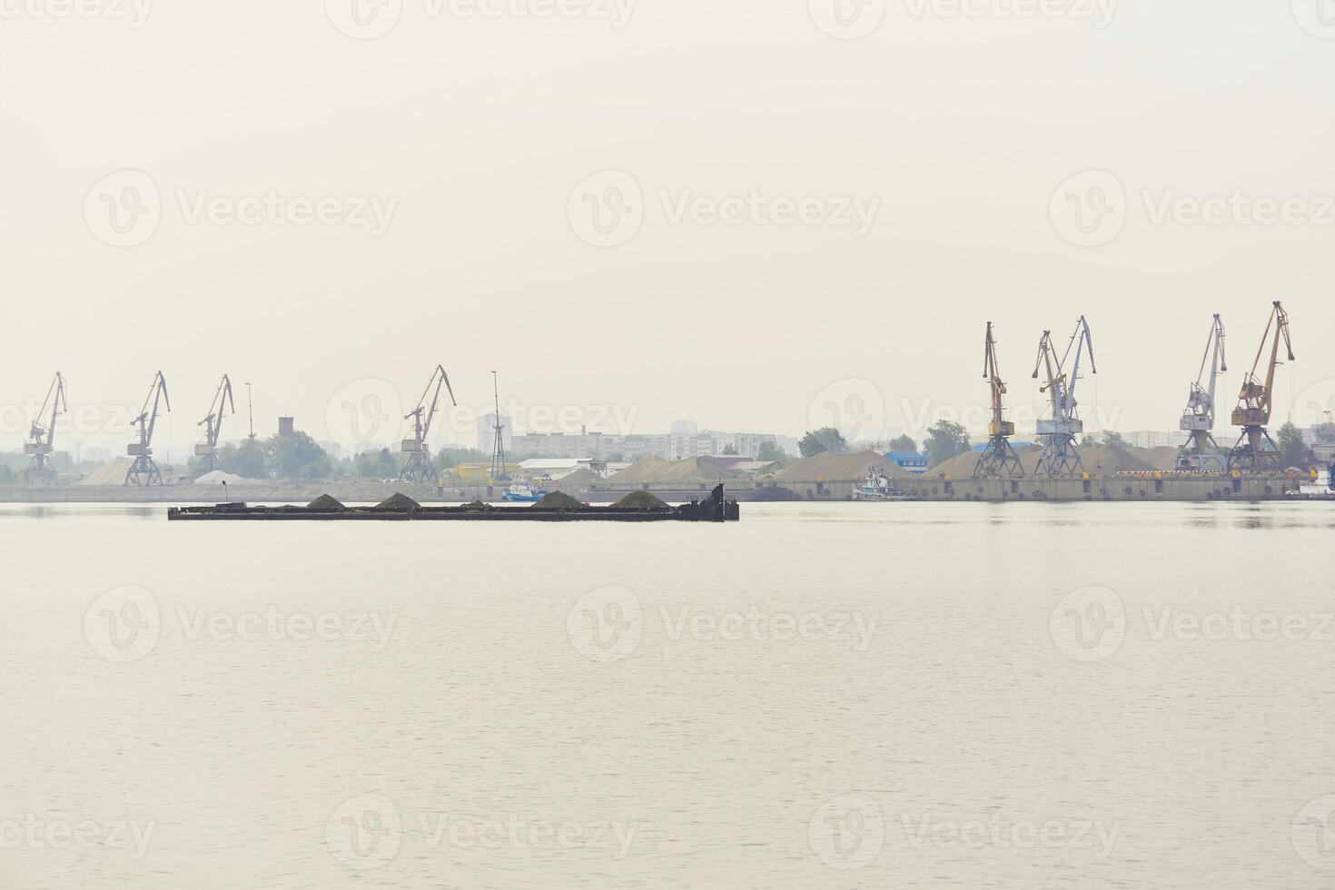 industrial river waterscape with dry cargo barge and cargo terminal in morning fog photo