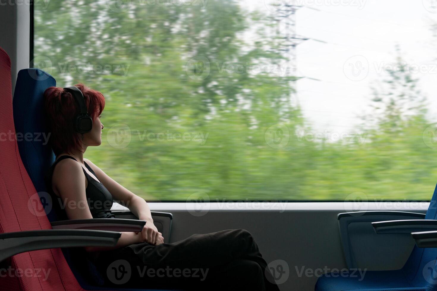 cirl in a moving suburban train looks out the window photo