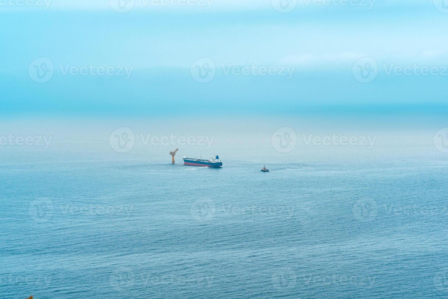 foggy seascape with a tanker near an oil terminal located far out to sea, top view photo