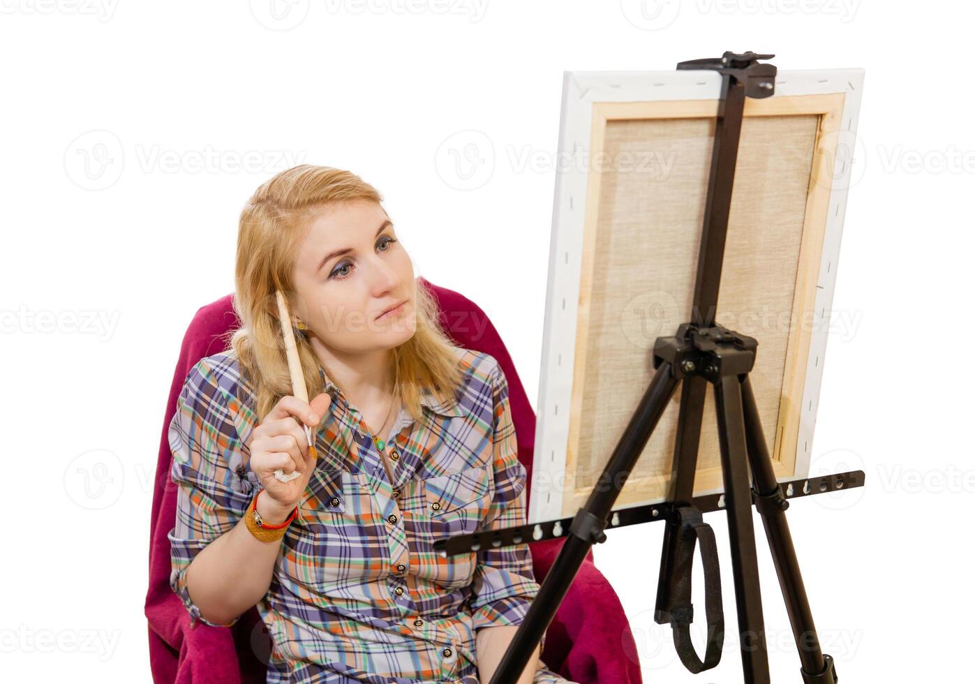 female artist looks thoughtfully at the canvas, on white background photo