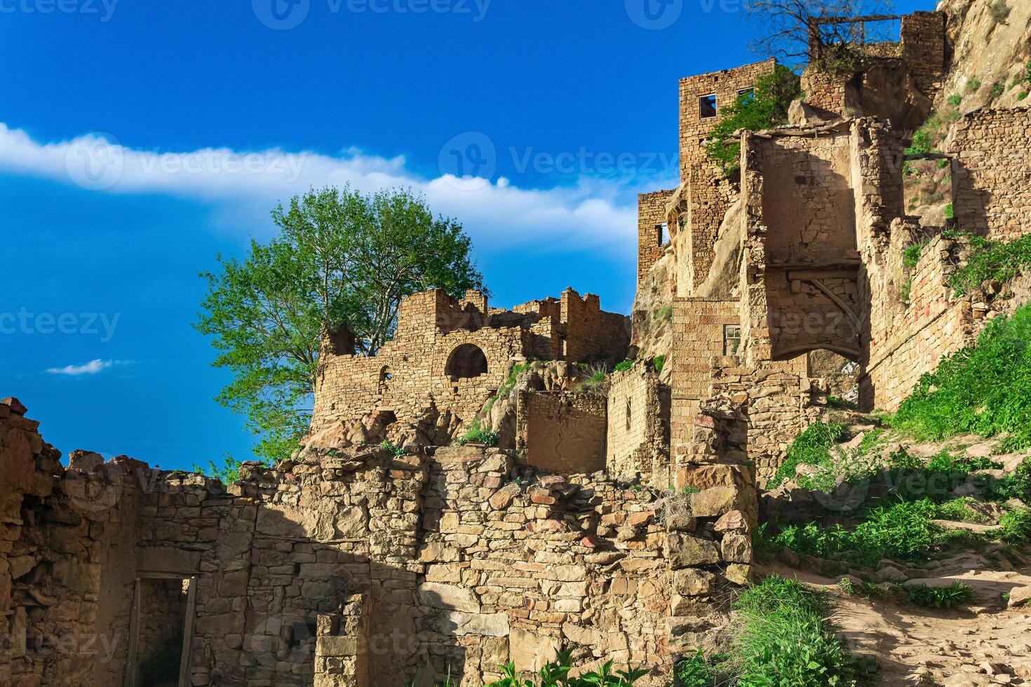 ruins of walls of houses on a cliff in the abandoned village of Gamsutl photo