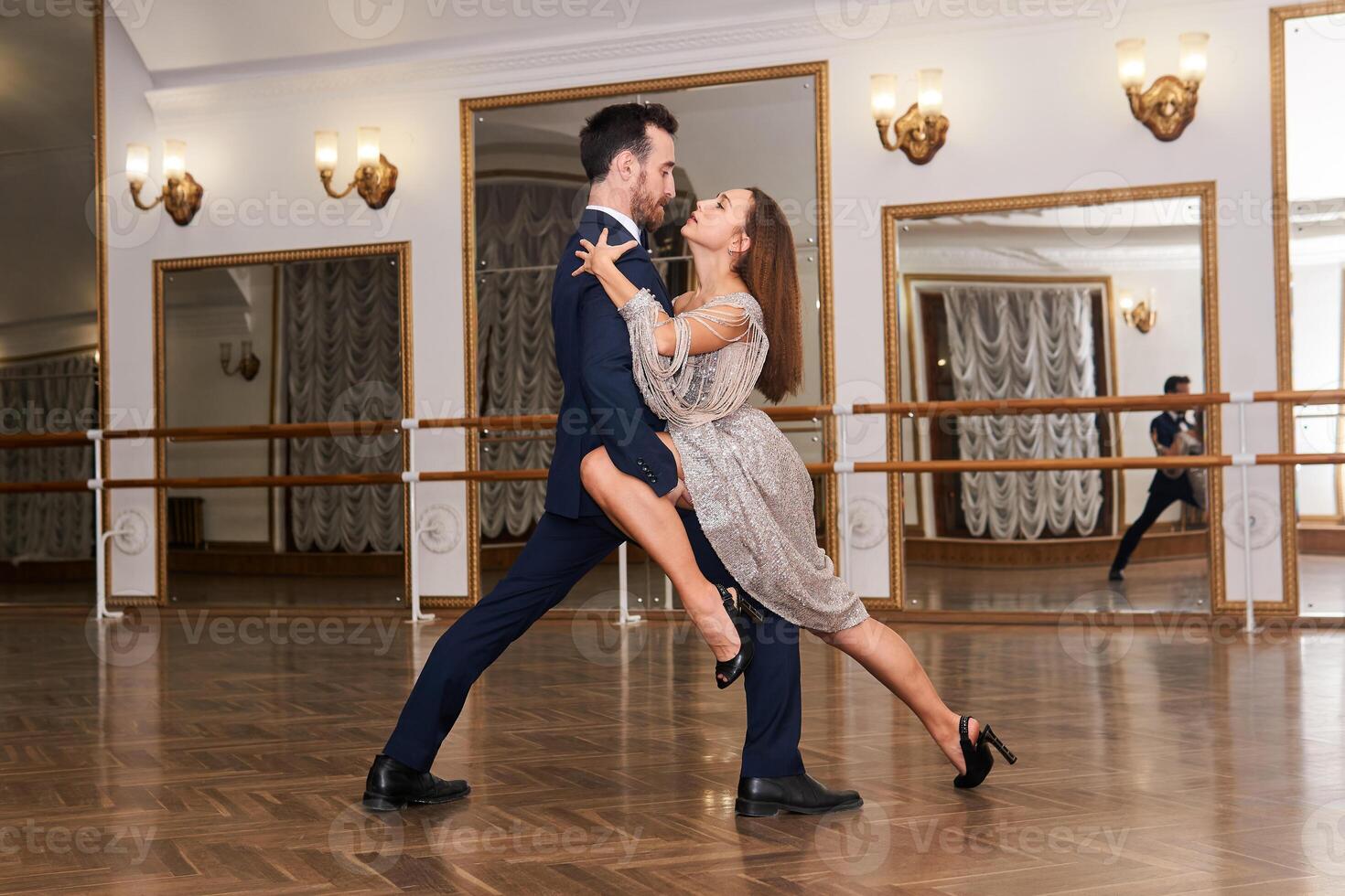 Pareja practicando bailando tango en un espacioso vacío salón foto