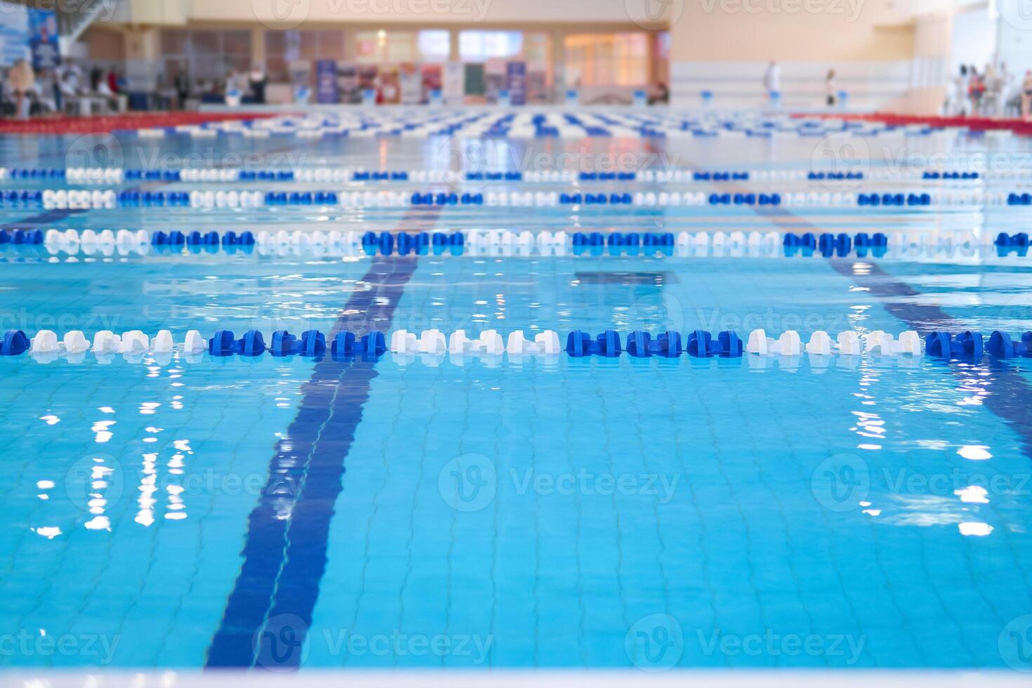 fragment of the competition pool with blue water and marked swimming lanes photo