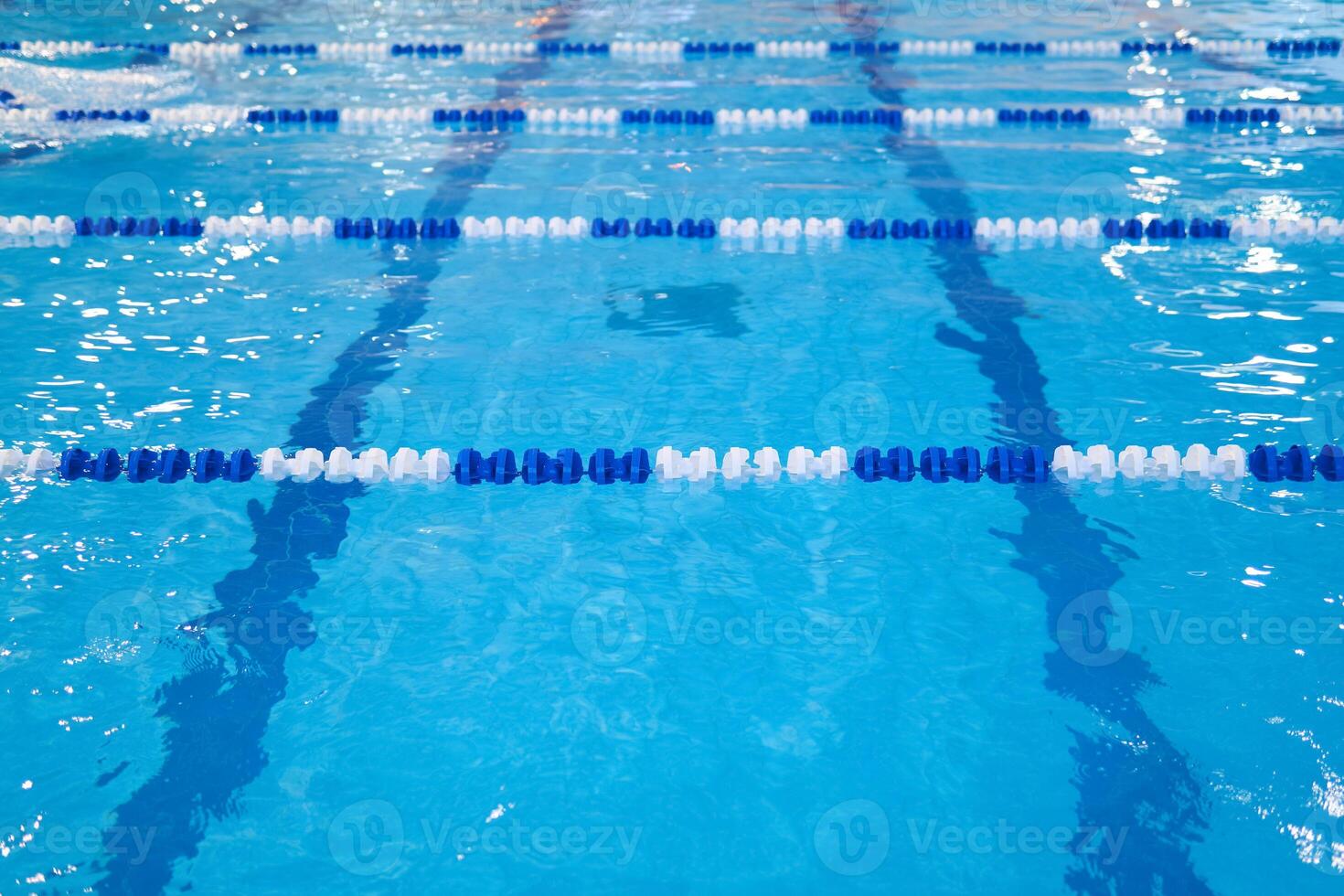 fragment of the competition pool with blue water and marked swimming lanes photo