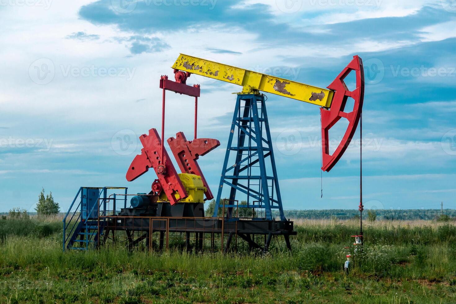 pumpjack operating at an oil well in field outdoors photo