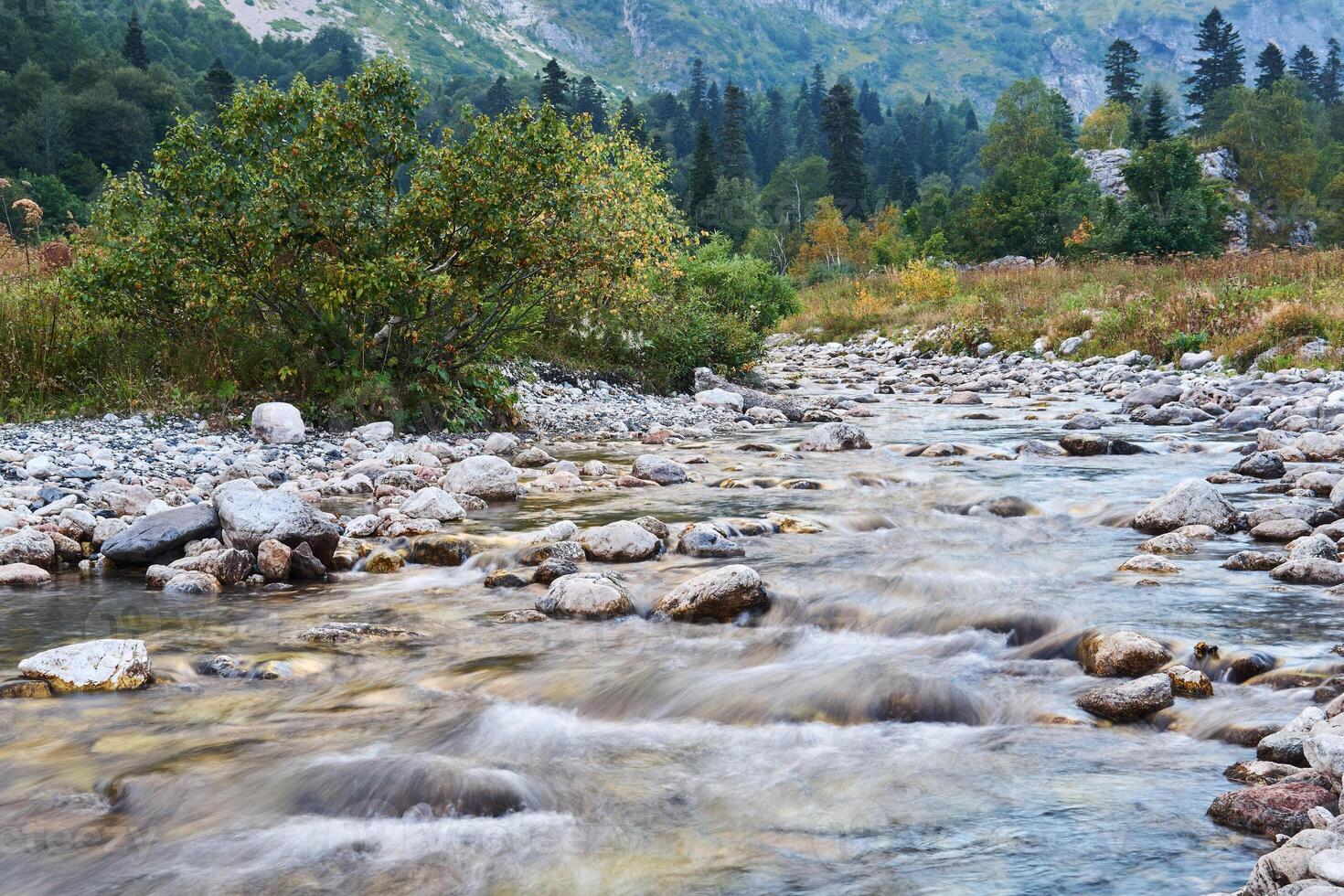 mountain river in autumn landscape, water blurred in motion photo