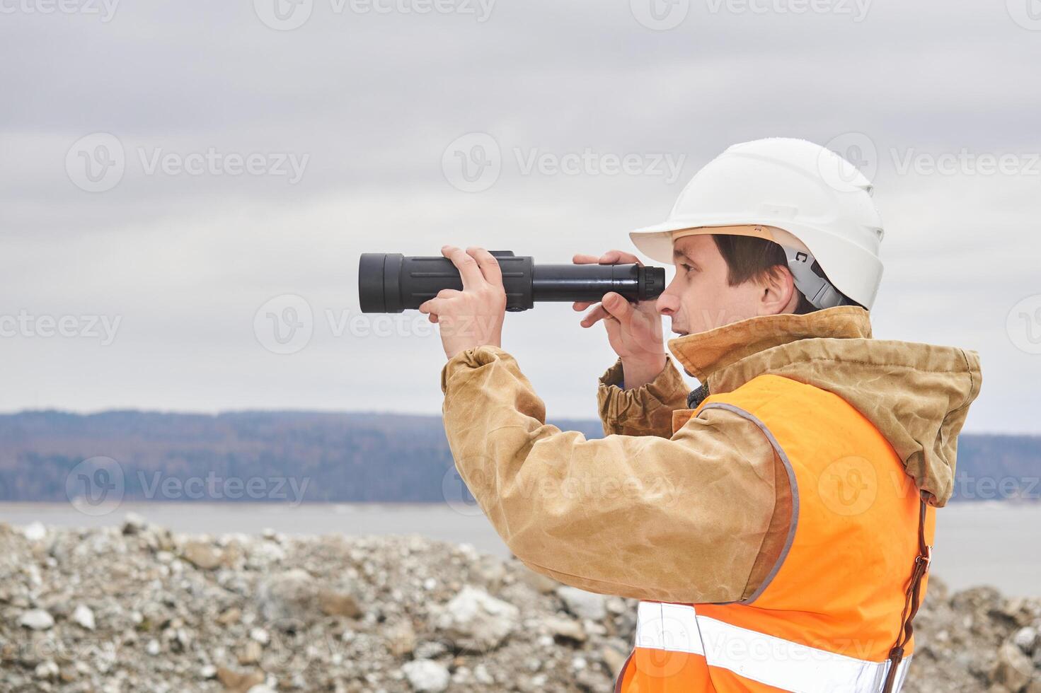 minería o la carretera ingeniero utilizando un punteo alcance en contra el antecedentes de un orilla del río cantera foto