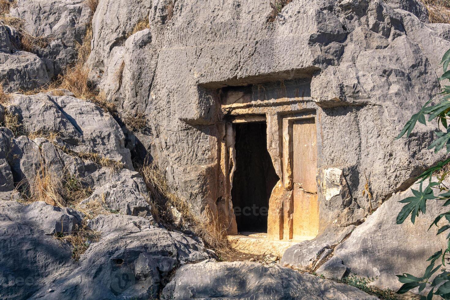 mysterious dark entrance to an ancient stone tomb, carved into the rock, in Myra Lycian now Demre, Turkey photo