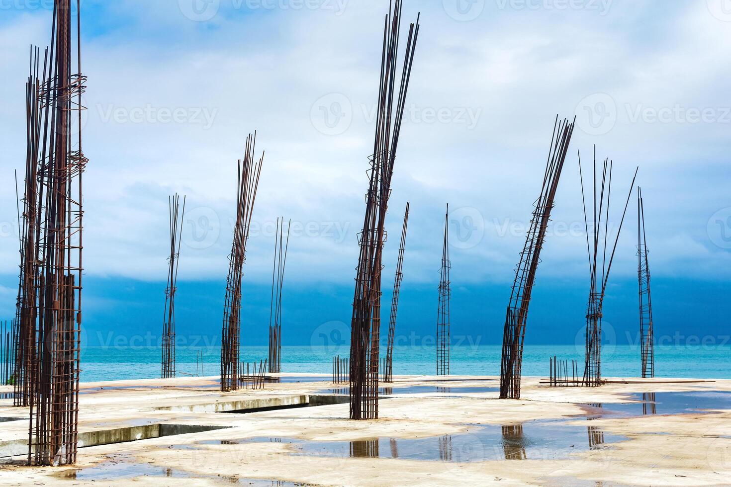 unfinished building with protruding rebar on the seashore photo
