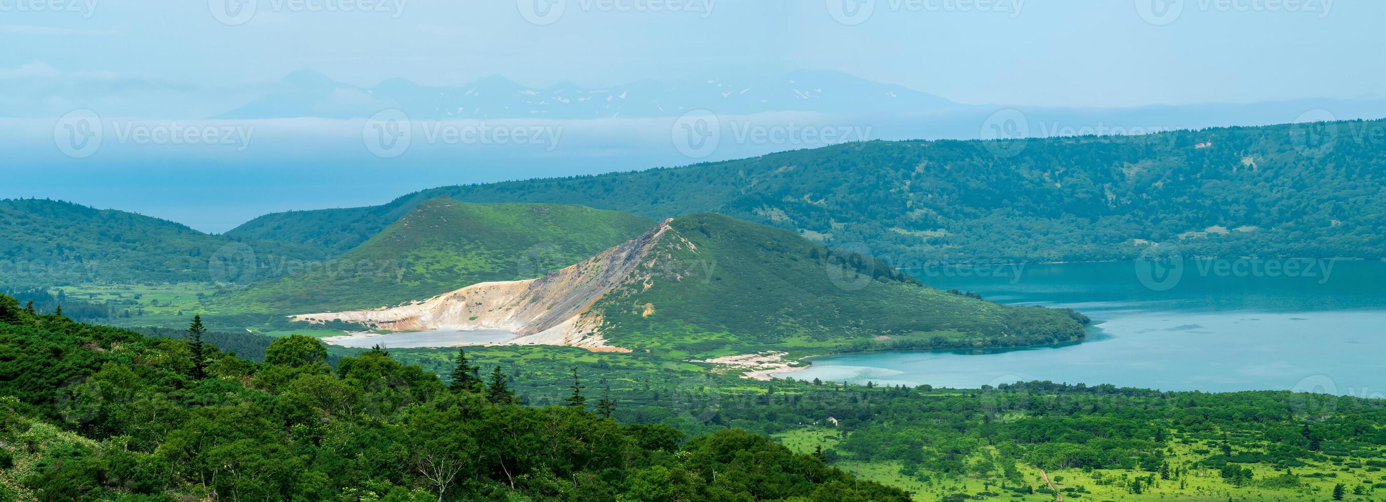 landscape of Kunashir Island, lakes and lava domes in the center of Golovnin volcano caldera the island of Hokkaido is visible in the distance in the sea photo