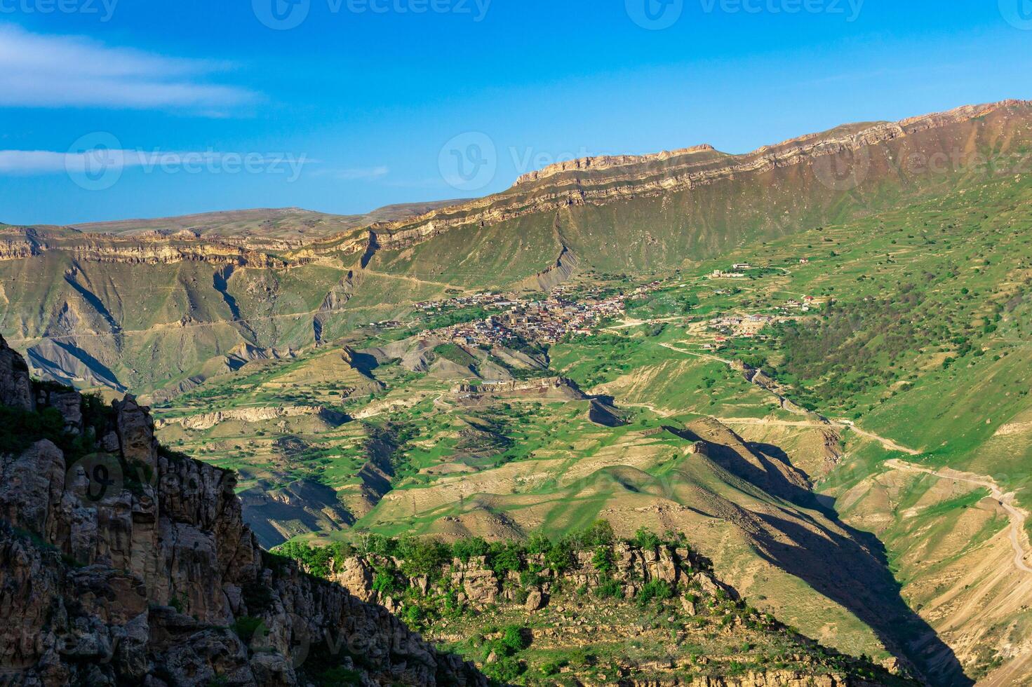 mountain landscape with a village on a slope under a huge rocky ridge, Chokh in Dagestan photo