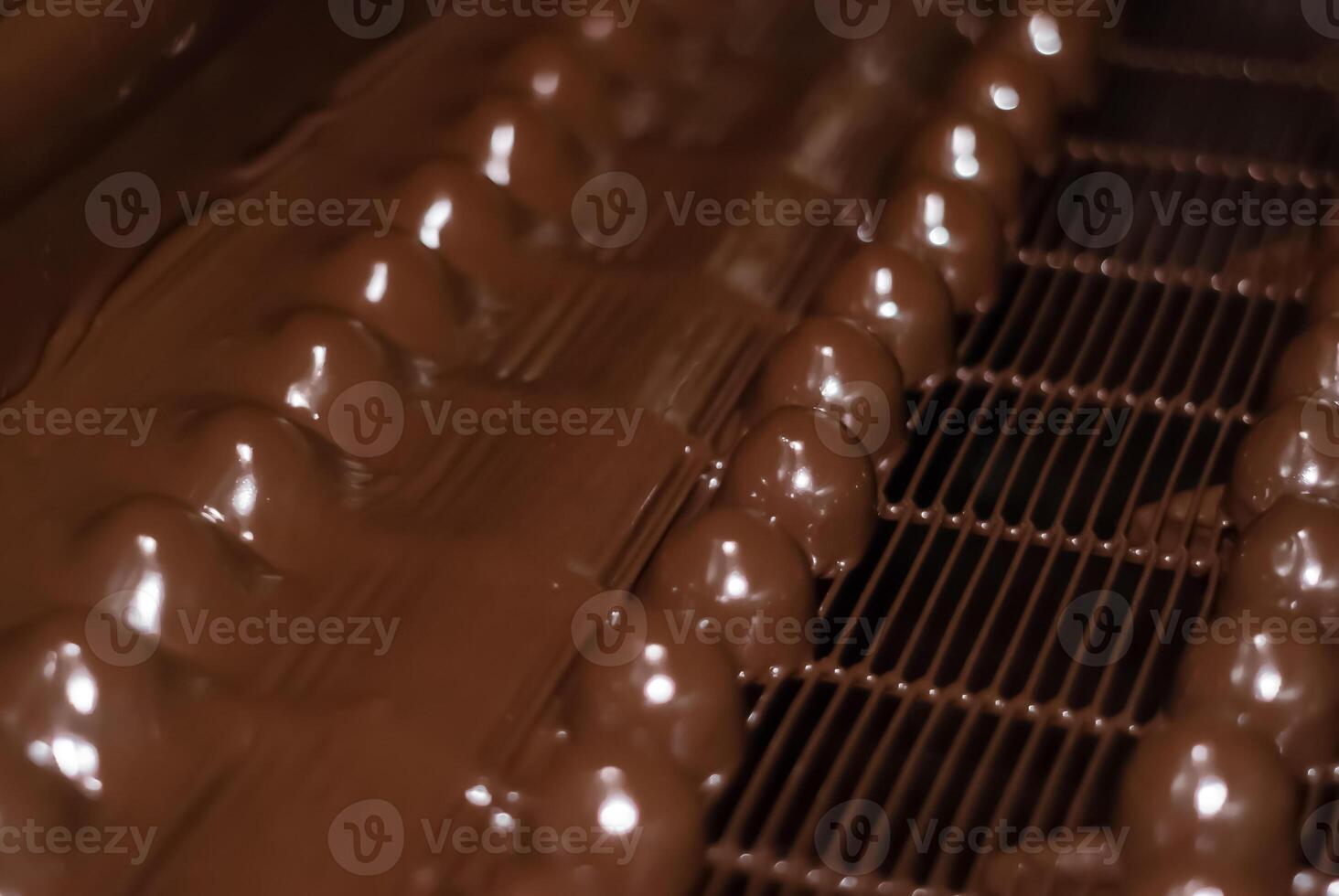 chocolate candies on the conveyor of a confectionery factory close-up photo