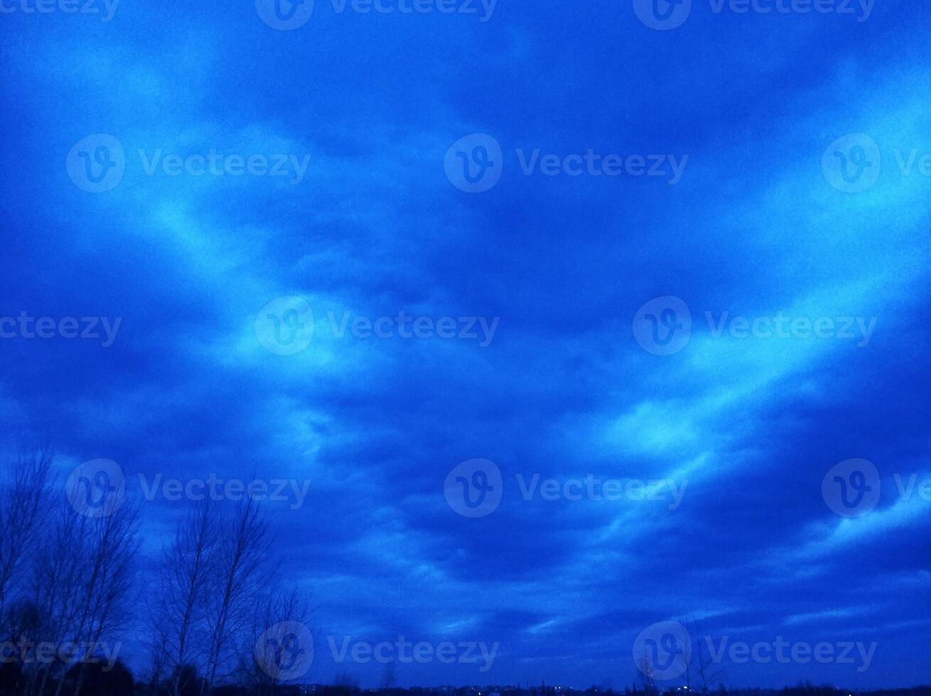 Incredibly bright evening blue sky with long clouds stretching across the sky photo